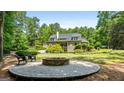 Backyard features a brick fire pit and patio area, with mature trees adding shade and privacy to the home at 130 Allie Drive, Mcdonough, GA 30252