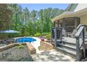 A pool surrounded by a patio and lush landscaping, complete with comfortable lounge chairs for relaxation at 130 Allie Drive, Mcdonough, GA 30252