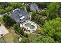Backyard oasis featuring a sparkling pool, lush landscaping, and outdoor lounging area at 405 Highgrove Dr, Fayetteville, GA 30215