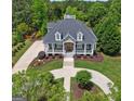 Expansive property featuring lush landscaping, circular driveway, and charming front porch at 405 Highgrove Dr, Fayetteville, GA 30215
