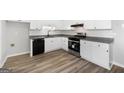 Modern kitchen with stainless steel appliances, granite counters, white cabinets, and wood-look flooring offers a fresh look at 1404 Meadowind Court Sw, Conyers, GA 30094