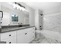 Bathroom with white marble, granite countertops, white cabinetry, and modern fixtures at 1425 Meadowind Court Sw, Conyers, GA 30094