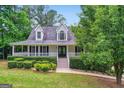Inviting two-story home featuring a classic front porch and lush greenery at 212 Warrenton Dr, Douglasville, GA 30134