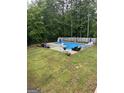 Backyard featuring a sparkling blue in-ground pool with surrounding patio space and lounge chairs at 212 Warrenton Dr, Douglasville, GA 30134