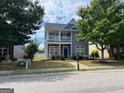 Two-story home with gray siding, stone accents, covered front porch and second-story balcony at 1218 Heartwood Ave, Mcdonough, GA 30253