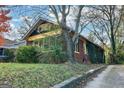 Brick home displaying classic architecture, a large tree, and vibrant ivy adorning the side of the residence at 1660 Rogers Sw Ave, Atlanta, GA 30310