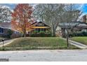 A charming brick home with a cozy, screened front porch complemented by the beauty of autumn foliage at 1660 Rogers Sw Ave, Atlanta, GA 30310