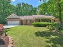 Landscaped front lawn with a two-car garage and covered porch of single-story brick home at 175 N Unity Grove Rd, Locust Grove, GA 30248