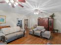 Cozy living room with hardwood floors, ceiling fans, and ample seating, including two comfortable couches at 175 N Unity Grove Rd, Locust Grove, GA 30248