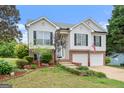 Charming two-story home featuring a brick-accented facade, two-car garage, and a landscaped front yard at 175 Dove Pt, Covington, GA 30016