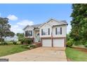 Charming two-story home features a brick-accented facade, two-car garage, landscaped front yard and long driveway at 175 Dove Pt, Covington, GA 30016
