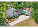 Aerial view showcases the home's inground pool, multiple garages, and lush surrounding greenery at 332 Judy Dr, Mcdonough, GA 30253