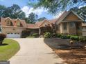 Exterior elevation with a well-maintained lawn, long driveway, and attached garage at 601 Sawgrass Walk, Mcdonough, GA 30253