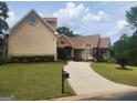 Exterior elevation with a well-maintained lawn, long driveway, and attached garage at 601 Sawgrass Walk, Mcdonough, GA 30253