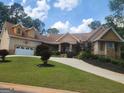 Charming exterior elevation with a well-maintained lawn and attached garage at 601 Sawgrass Walk, Mcdonough, GA 30253