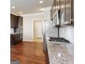 Well-equipped kitchen with granite countertops, stainless steel appliances, dark wood cabinets and hardwood flooring at 3970 Lagrone St, Powder Springs, GA 30127