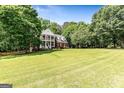 Charming two-story brick home with a double porch and a spacious, well-manicured front lawn at 218 Woodruff Way, Peachtree City, GA 30269