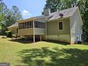 Back exterior view of house showing screened in porch area in a well-maintained backyard at 105 Old Hickory Pointe, Mcdonough, GA 30252