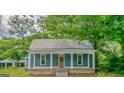 Single-story home showcasing a quaint porch with sturdy columns and a durable metal roof at 1128 Milstead Ne Ave, Conyers, GA 30012
