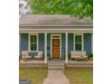 Inviting front porch featuring a seating area with a stylish blue exterior and matching furniture at 1128 Milstead Ne Ave, Conyers, GA 30012