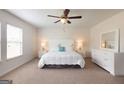 Bright bedroom features neutral decor, large window, ceiling fan, and a matching bedroom set at 2358 Argento Cir, Dacula, GA 30019