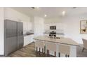 Bright kitchen featuring a large island with granite countertops, stainless appliances, and white cabinets at 2358 Argento Cir, Dacula, GA 30019