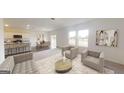 A furnished living room features two large windows, neutral walls and decor at 2358 Argento Cir, Dacula, GA 30019
