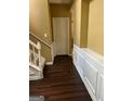 Hallway with dark wood flooring, staircase, and white door, blending functionality with style at 3838 Kirkwood Nw Run, Kennesaw, GA 30144