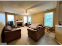 Cozy living room featuring a brick fireplace and ample natural light from the large windows at 3838 Kirkwood Nw Run, Kennesaw, GA 30144