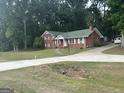 Exterior view of a brick home with a long concrete driveway and ample green space at 603 New Hope Rd, Fayetteville, GA 30214