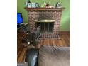 Living room featuring a brick fireplace and original hardwood floors at 603 New Hope Rd, Fayetteville, GA 30214