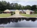 Street view of single-story homes with brick and tan facades, garages, and green lawns at 6190 Douglas Manor Ct, Douglasville, GA 30134