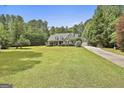 Landscaped home on a sprawling green lawn provides privacy and a sense of tranquility at 465 Crabapple Rd, Fayetteville, GA 30215