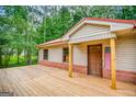Inviting front porch featuring wood decking, brick accents, and a charming entryway with patriotic décor at 428 Cornish Mountain Rd, Oxford, GA 30054