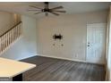Living room with light gray wood floors, tv wall mount, staircase and white front door at 2108 Remy Ct, Kennesaw, GA 30144