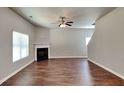 This large living room features a fireplace, ceiling fan, and large windows at 620 Sedona Loop, Hampton, GA 30228