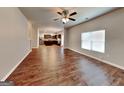 Spacious open-concept living room with gleaming hardwood floors, ceiling fan and natural light at 620 Sedona Loop, Hampton, GA 30228