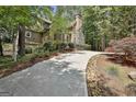 Long driveway leading to a beautiful home surrounded by mature trees and landscaping at 100 Rosemont, Peachtree City, GA 30269