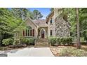 Inviting home exterior showcasing a stone chimney, stucco facade, and landscaped entrance at 100 Rosemont, Peachtree City, GA 30269