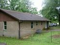 Brick home with a brown roof and a chain link fence in the background at 981 E Atlanta Rd, Stockbridge, GA 30281