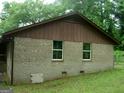 Side view of a brick home with a brown roof and a small window at 981 E Atlanta Rd, Stockbridge, GA 30281
