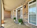 Inviting front porch with stone accents and decorative plants near the front door at 211 English Oaks Ln, Mcdonough, GA 30253