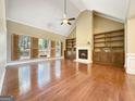 Spacious living room featuring a fireplace, built-in shelves, and hardwood floors at 211 English Oaks Ln, Mcdonough, GA 30253