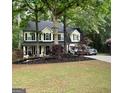Lovely two-story home with black shutters, a well-maintained lawn and mature trees at 6520 Glen Pond Trce, Cumming, GA 30028