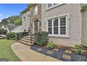 Stunning home entrance with stone steps, iron railings, and manicured landscaping at 604 Magnolia Ln, Peachtree City, GA 30269