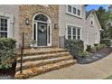 Elegant home entrance featuring stone steps, a decorative wreath, and stylish lighting fixtures at 604 Magnolia Ln, Peachtree City, GA 30269