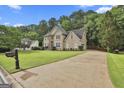 Inviting home with a long driveway, well-kept lawn, and mature trees at 604 Magnolia Ln, Peachtree City, GA 30269