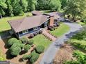 An aerial view of a charming home featuring a brick chimney, large windows, well-manicured lawn, driveway, and garage at 200 Camp Creek Trail, Peachtree City, GA 30269