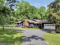 Charming home featuring a brick chimney, large windows, well-manicured lawn, driveway, and two-car garage at 200 Camp Creek Trail, Peachtree City, GA 30269