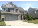 Inviting two-story home with a well-manicured lawn and brick facade, featuring an attached two-car garage at 2282 Joplin St, Jonesboro, GA 30236